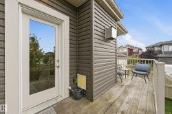 Exterior deck with wood-finish flooring, white railing, and brown siding - 