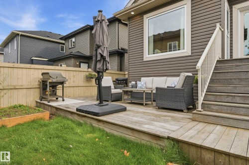 Elevated wood-finish deck with stairs, a privacy fence, and a grassed yard area - 1961 Adamson Terrace Sw, Edmonton, AB 