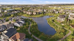 Expansive residential area with a prominent central lake, winding pathways, and green spaces - 