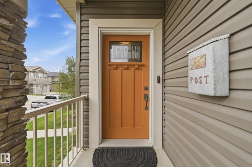Craftsman-style front door with leaded glass insert, stone veneer column, and horizontal siding - 1961 Adamson Terrace Sw, Edmonton, AB 