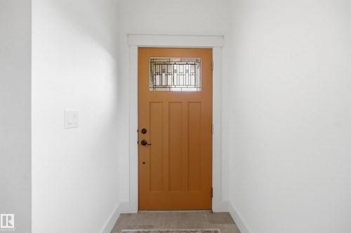 Craftsman-style entry door with decorative glass panels, modern black hardware, and white trim - 1961 Adamson Terrace Sw, Edmonton, AB 