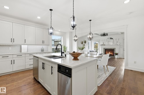 Kitchen featuring white shaker cabinetry, white countertop surfaces, stainless steel appliances, and wood-finish flooring - 1961 Adamson Terrace Sw, Edmonton, AB 