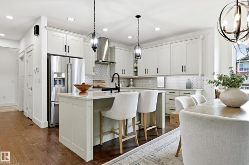 White shaker cabinetry, stainless steel appliances, honeycomb tile backsplash, wood-finish flooring, and recessed ceiling lighting - 1961 Adamson Terrace Sw, Edmonton, AB 