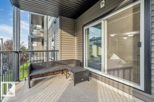 Private balcony with concrete flooring, black metal railings, and vinyl siding - #224 390 Windermere Rd Nw, Edmonton, AB 