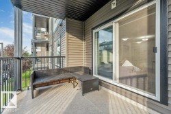Private balcony with concrete flooring, black metal railings, and vinyl siding - 