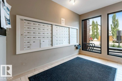 Mailbox wall unit with individual compartments, track lighting, and tile flooring - #224 390 Windermere Rd Nw, Edmonton, AB 