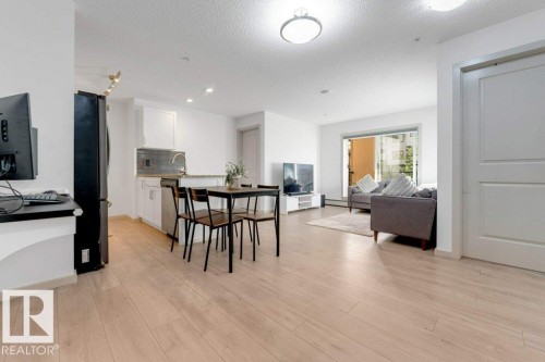 Open-concept living space featuring light wood-finish flooring - #224 390 Windermere Rd Nw, Edmonton, AB 