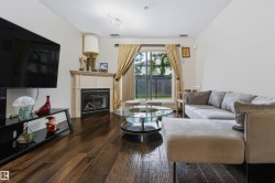 Hardwood flooring throughout, a fireplace with a mantel, and a sliding glass door - 