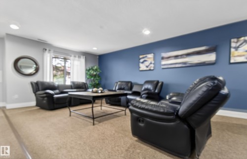 Recessed lighting, carpet flooring, window with white sheers, contrasting accent wall - #155 2096 Blackmud Creek Dr Sw, Edmonton, AB 