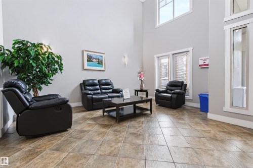 High ceilings and light gray walls complement the rectangular floor tiles - #155 2096 Blackmud Creek Dr Sw, Edmonton, AB 