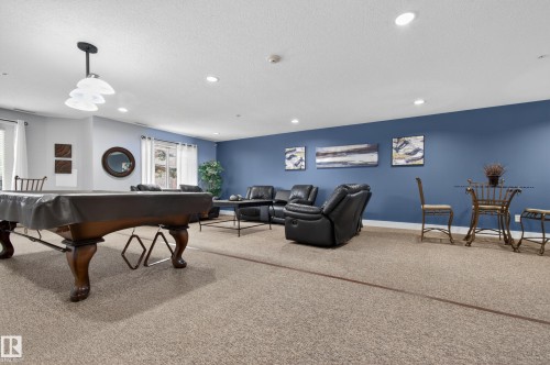 Recessed ceiling lighting, carpeted flooring, pendant lighting fixture, multiple windows, built-in pool table - #155 2096 Blackmud Creek Dr Sw, Edmonton, AB 