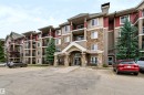 Multi-story building featuring stone and siding exterior, multiple balconies, and a covered main entrance - #155 2096 Blackmud Creek Dr Sw, Edmonton, AB 