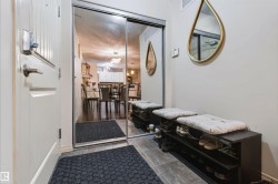 Mirrored closet doors, tiled flooring, built-in shoe storage, and a white paneled entry door - 