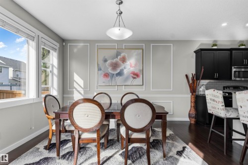 Wood-finish flooring, white trim detailing, and a contemporary overhead light fixture - 8515 19 Avenue Sw, Edmonton, AB 