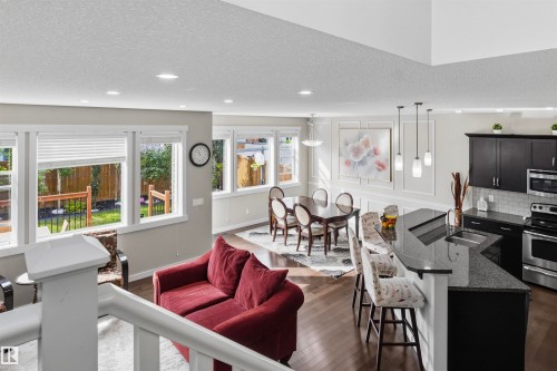Open-concept living space with dark wood-finish flooring - 8515 19 Avenue Sw, Edmonton, AB 