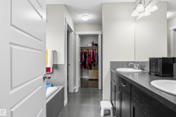 Dual vanity with undermount sinks, chrome fixtures, and a dark countertop - 