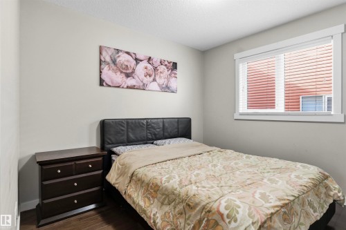 Wall-to-wall wood-finish flooring, white trim window, and light neutral wall color - 8515 19 Avenue Sw, Edmonton, AB 