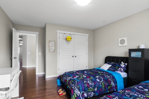 Hardwood-finish flooring, light grey walls, white trim, and a white paneled closet door - 8515 19 Avenue Sw, Edmonton, AB 