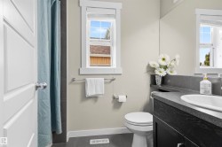 Vanity with an integrated sink, dark wood-finish cabinetry, and a dark countertop - 