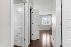 Wood-finish flooring throughout, white paneled doors, and a window with blinds - 