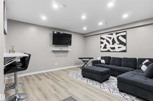 Recessed lighting, wood-finish flooring, and a wall-mounted media shelf - 8515 19 Avenue Sw, Edmonton, AB 