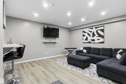 Recessed lighting, wood-finish flooring, and a wall-mounted media shelf - 