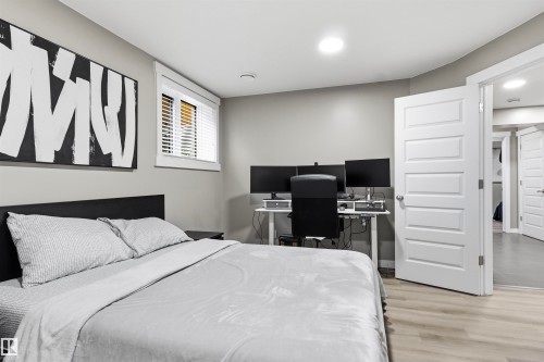 Recessed lighting, light-toned walls, wood-finish flooring, white paneled door, and a window with white blinds - 8515 19 Avenue Sw, Edmonton, AB 