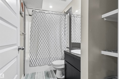 White paneled door, built-in shelving, dark wood-finish vanity with an undermount sink, and recessed lighting - 8515 19 Avenue Sw, Edmonton, AB 