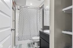 White paneled door, built-in shelving, dark wood-finish vanity with an undermount sink, and recessed lighting - 