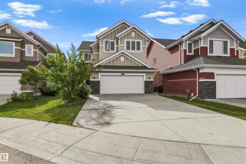 Two-story residence featuring a gabled roofline, stone facade accents, and a front-facing garage - 8515 19 Avenue Sw, Edmonton, AB 