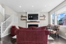 Recessed lighting, wood-finish flooring, white staircase railing, electric fireplace with wood mantel, and large windows - 8515 19 Avenue Sw, Edmonton, AB 