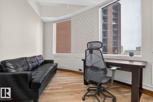 Hardwood flooring, multiple windows, decorative wall paneling, and baseboard molding - #501 10105 109 St Nw, Edmonton, AB 