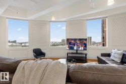 Curved wall with multiple windows, decorative wall panels, wood-finish flooring, and recessed ceiling lighting - 