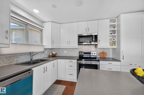 White cabinetry and stainless steel appliances - 7704 13 Avenue Nw, Edmonton, AB 