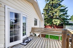 Exterior featuring a wood deck, French doors with grilles, and horizontal siding - 