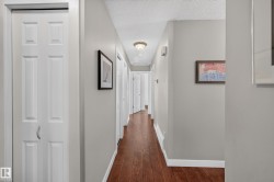 Hardwood-finish flooring, light gray wall paint, multiple paneled doors, and ceiling-mounted lighting - 