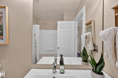 White vanity with an integrated sink and chrome faucet - 7704 13 Avenue Nw, Edmonton, AB 