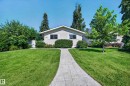 Single-story residence featuring light-colored siding, a pitched roof, and a paved walkway - 7704 13 Avenue Nw, Edmonton, AB 