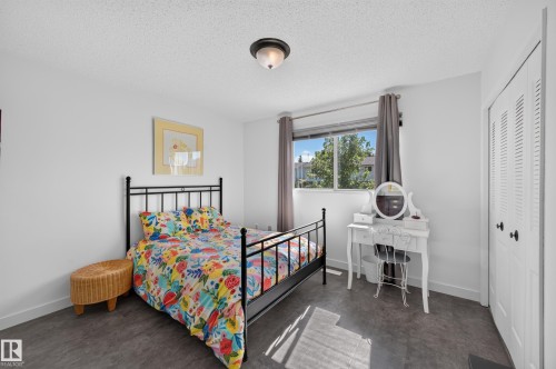 Spacious room with durable gray flooring and a window providing natural light - 7704 13 Avenue Nw, Edmonton, AB 