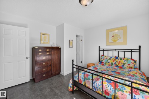 White painted walls, dark flooring, and a six-panel interior door - 7704 13 Avenue Nw, Edmonton, AB 
