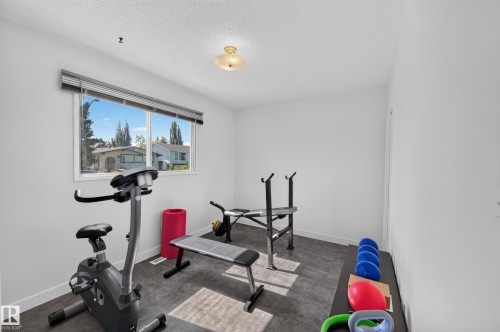 Recessed window with horizontal blinds, wood-finish flooring, and a flush-mount ceiling light - 7704 13 Avenue Nw, Edmonton, AB 