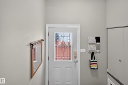 Entry door with decorative glass inserts, adjacent to built-in storage with bi-fold doors - 