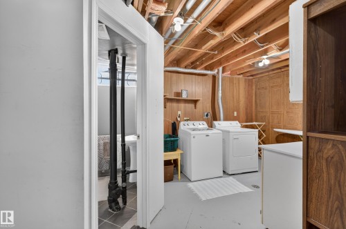 Wood paneling, exposed ceiling joists, light gray flooring, built-in shelving, and white appliances - 7704 13 Avenue Nw, Edmonton, AB 