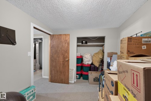 Carpeted flooring, wood-finish door, and integrated closet shelving - 7704 13 Avenue Nw, Edmonton, AB 