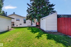 Expansive grassy yard with a detached shed and a separate storage structure - 