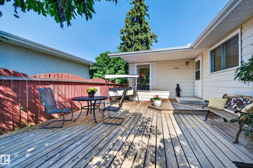 Expansive wood deck with a privacy fence, exterior siding, and a window - 7704 13 Avenue Nw, Edmonton, AB 