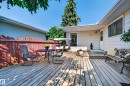 Expansive wood deck with a privacy fence, exterior siding, and a window - 7704 13 Avenue Nw, Edmonton, AB 