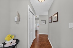 Hallway featuring wood-finish flooring, light grey walls, and a recessed ceiling light - 