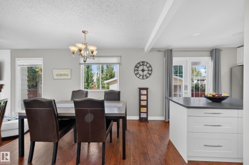 Wood-finish flooring, white walls, and a multi-light chandelier - 7704 13 Avenue Nw, Edmonton, AB 