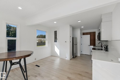 Recessed lighting, wood-finish flooring, white walls, white cabinetry, and stainless steel appliances - 11914 124 Street Nw, Edmonton, AB 